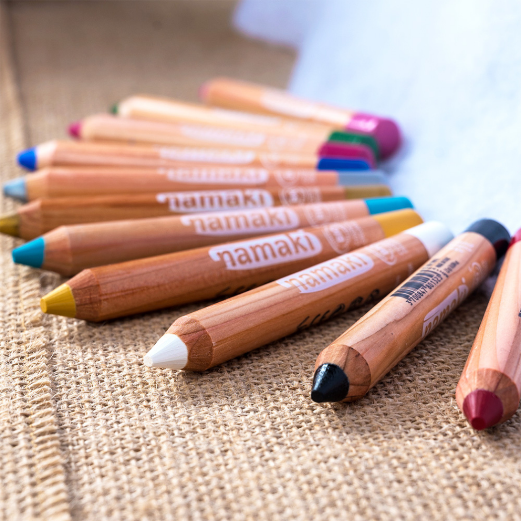 Namaki Schminkstift dick in verschiedenen Farben nebeneinander auf Textilstoff, mit farbigen Spitzen