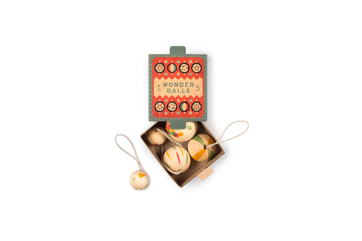 Grapat Ornaments Nº5 Wonder Balls, offene Schachtel mit den bemalten Holzkugeln, eine hängt an der Schnur daneben