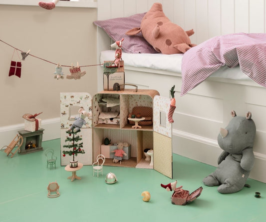 Kinderzimmer mit Maileg Mäusehaus im Koffer, davor der kleine geschmückte Tannenbaum und Stofftiere