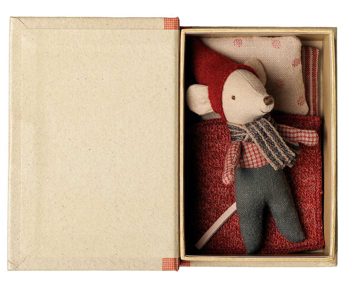 Aufgeklapptes Maileg Buch von oben: die Babymaus mit roter Mütze liegt im Bett unter einer roten Decke