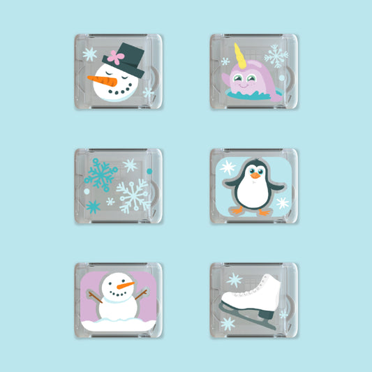 Sechs Glo Pals Leuchtwürfel mit Wintermotiven: zwei Schneemänner, Narwal, Schneeflocken, Pinguin und Schlittschuh