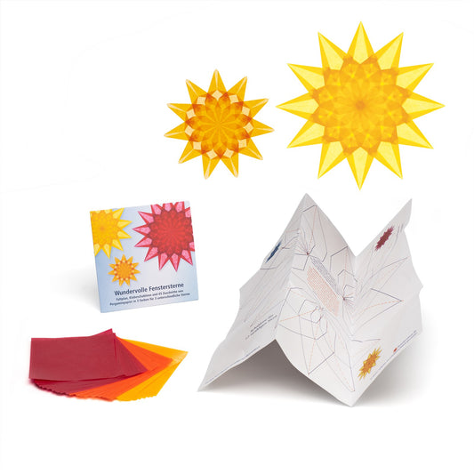 Ausgepacktes Set Wundervolle Fenstersterne: Kartontasche, Pergaminpapier in Rot, Orange und Gelb, aufgestellter Faltplan und zwei fertige Sterne in Gelb und Orange