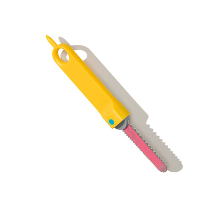 Makedo Safe-Saw Kartonsäge mit gelbem Griff, grauer Sägeblattabdeckung und rosa Sägeblatt, Packshot vor weißem Hintergrund