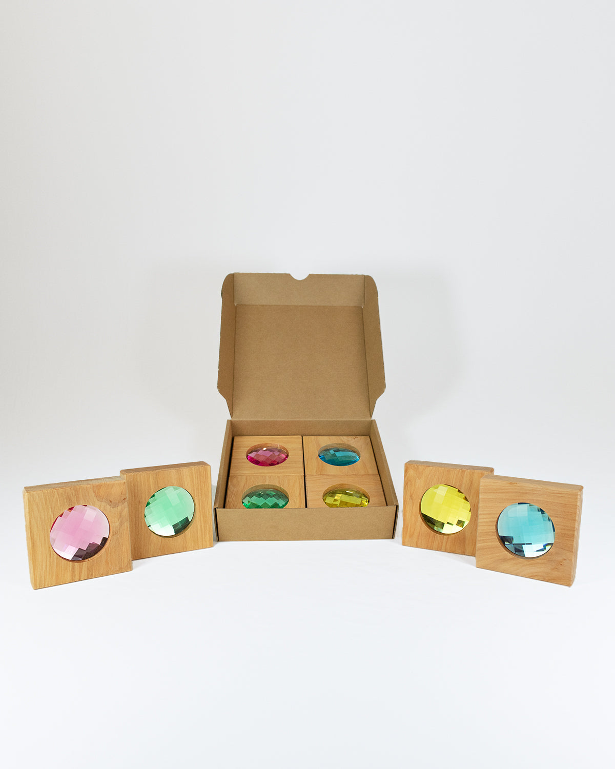 Bauspiel Riesen Funkelklötze, Kartonbox mit Holzklötzen und bunten facettierten Funkelsteinen in Rosa, Grün, Türkis, Gelb und Hellblau