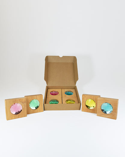 Bauspiel Riesen Funkelklötze, Kartonbox mit Holzklötzen und bunten facettierten Funkelsteinen in Rosa, Grün, Türkis, Gelb und Hellblau