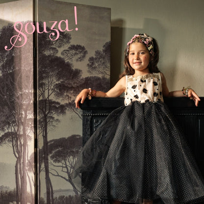 Kind trägt Souza Noella Kostümkleid neben Wandpaneel mit Waldmotiv und rosafarbenem Schriftzug