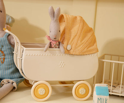 Kleiner Stoffhase sitzt im cremefarbenen Maileg Kinderwagen mit gelb kariertem Verdeck, Nahaufnahme