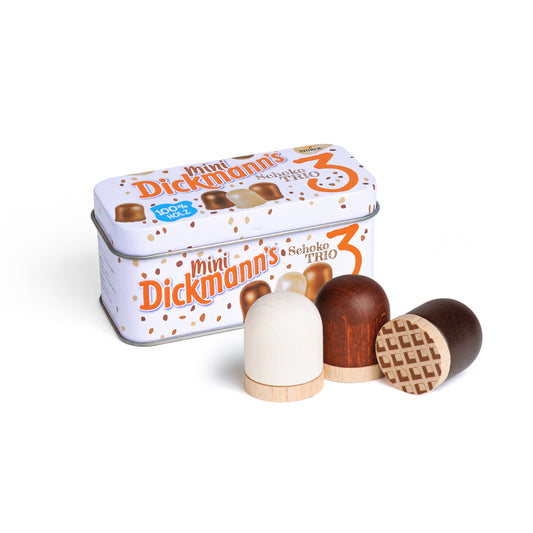 Erzi Mini Dickmanns in der Blechdose, davor drei Holz-Schokoküsse in Weiß, Braun und mit Waffelmuster