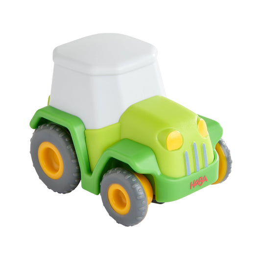 Haba Traktor aus Kunststoff in Grün mit weißer Fahrerkabine und gelben und orangefarbenen Details
