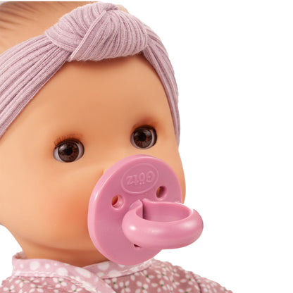 Götz Sleepy Aquini Girl Babypuppe mit lila Stirnband und rosa Schnuller im Mund, Nahaufnahme Kopf und Oberkörper