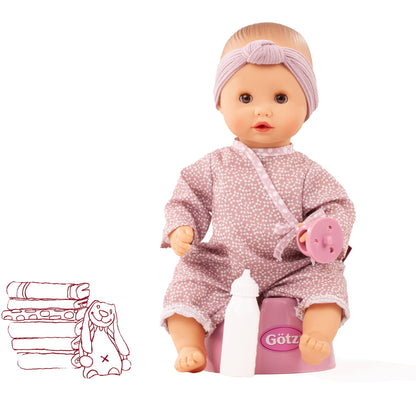 Götz Sleepy Aquini Girl Soft Mood mit lila Stirnband und altrosa gemustertem Overall, sitzt auf dem rosa Töpfchen
