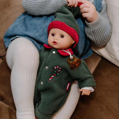 Kind hält die Götz Muffin Baby Christmas Candy im grünen Overall mit Zipfelmütze auf dem Schoß