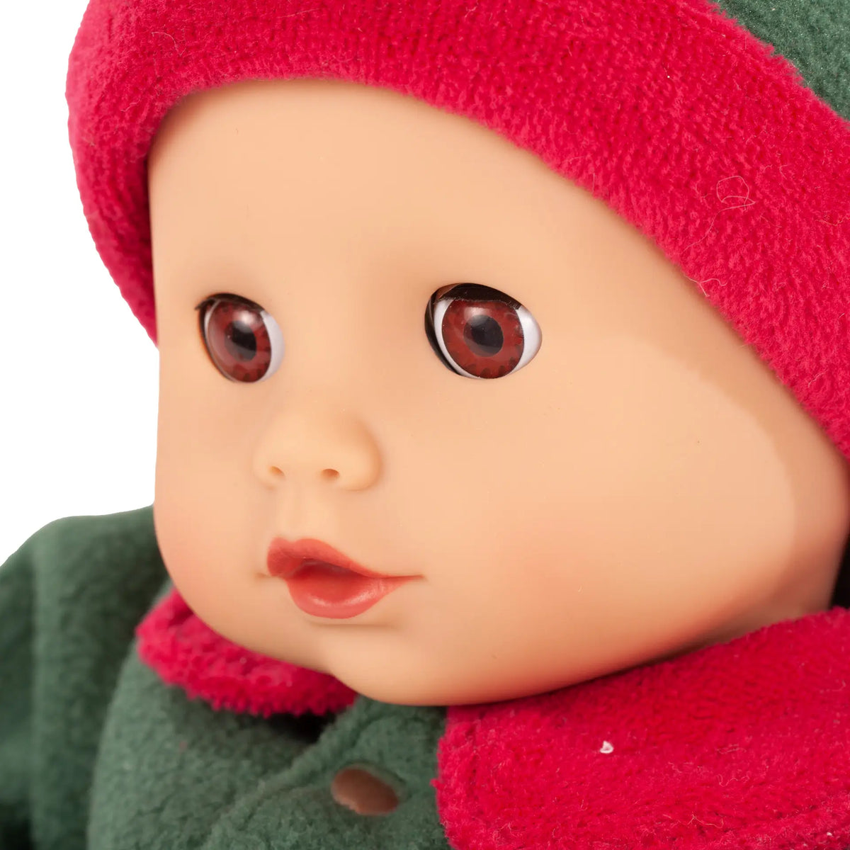 Nahaufnahme des Gesichts der Götz Muffin Baby Christmas Candy mit braunen Augen, rotem Mützenrand und grünem Overall