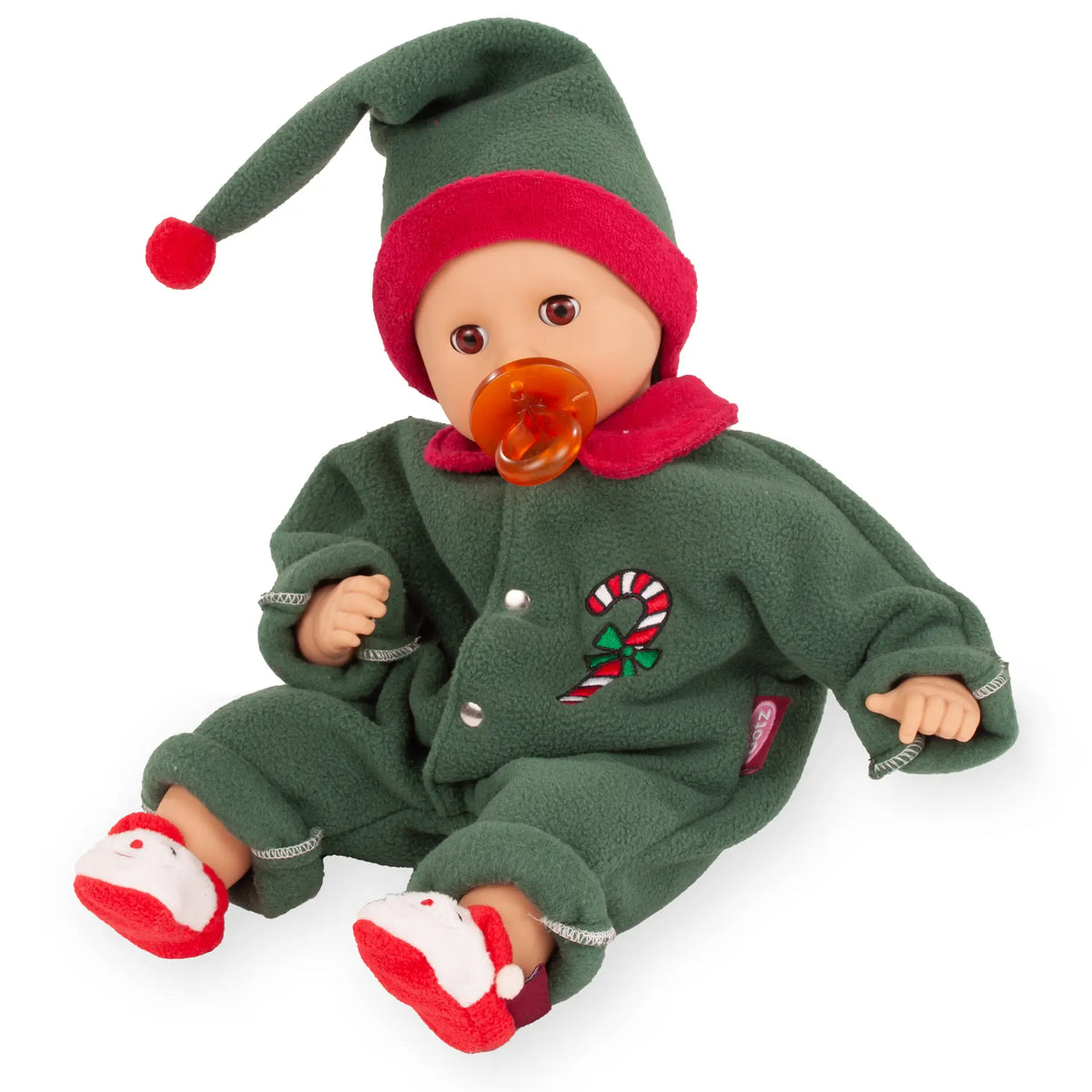 Götz Muffin Baby Christmas Candy mit orangefarbenem Schnuller, grünem Overall, Zipfelmütze und Weihnachtsmann-Puschen