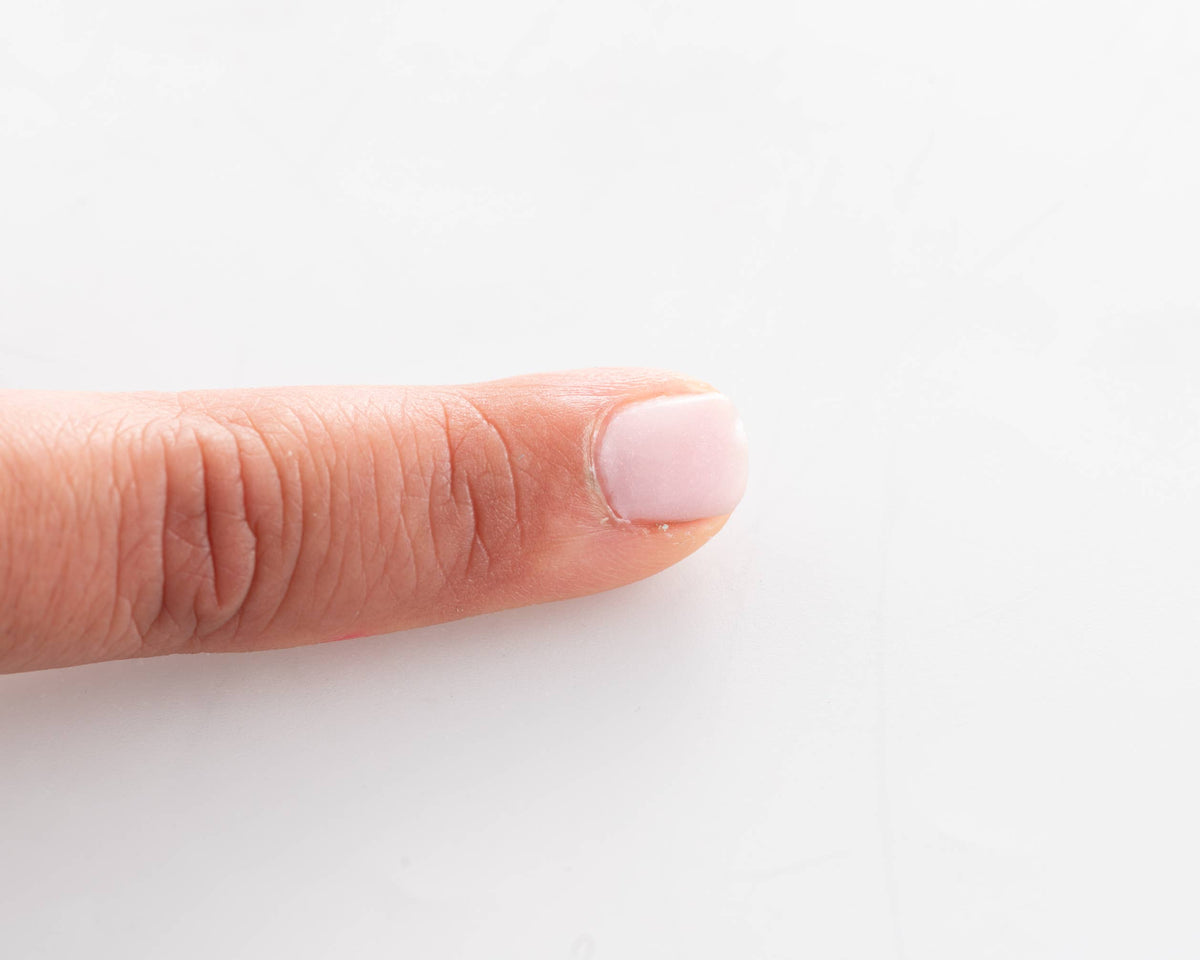Namaki Nagellack abziehbar in Hellrosa auf dem Fingernagel einer Hand aufgetragen