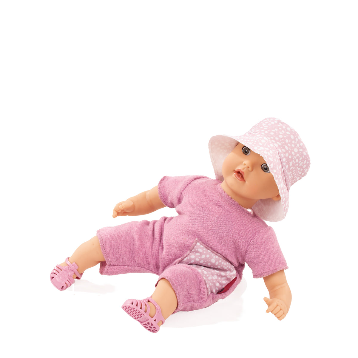 Götz Babypuppe trägt die Babykombi Sommer: rosa Frottee-Overall, getupfter Sonnenhut und rosa Sandalen
