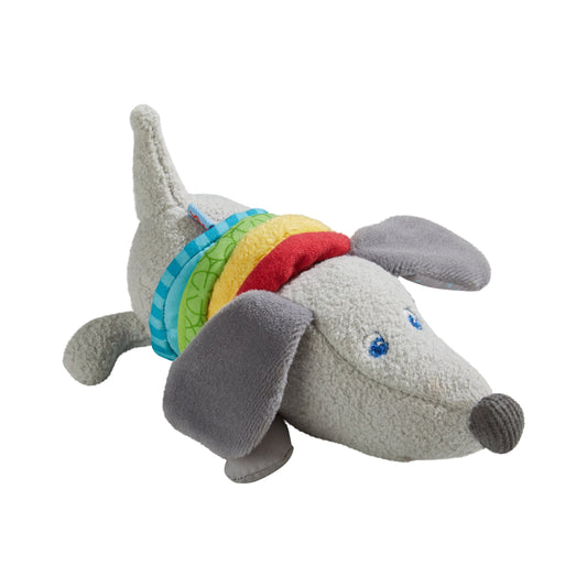 Haba Ratterfigur Dackel aus grauem Stoff mit buntem Regenbogen-Muster um den Rücken, gestreckt liegende Position