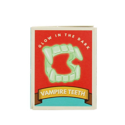 Verpackung der Rex London Vampirzähne mit rotem Hintergrund, grünen leuchtenden Zähnen und schwarzem Banner mit goldenem Text
