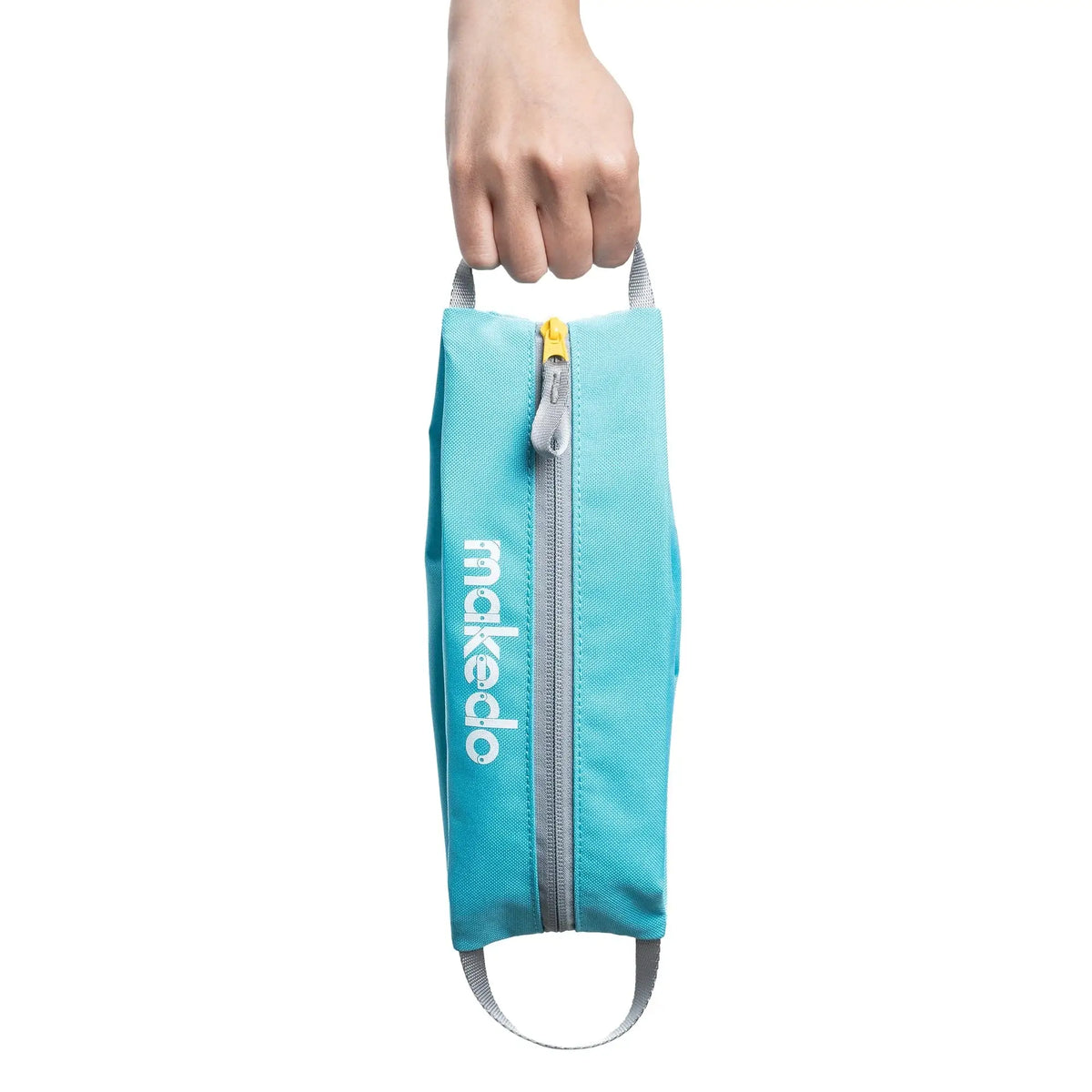 Hand hält türkise Makedo Tool-Case Tasche an einem Henkel mit Reißverschluss und weißem Schriftzug