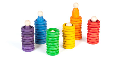 Grapat Nins, Rings & Coins, sechs Türme aus Ringen in Regenbogenfarben, oben je ein Nin