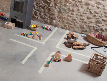 Grapat Houses and Nins auf Spielfläche arrangiert mit Holzhäusern, bunten Holzfiguren, Naturmaterialien und Körben in Szene