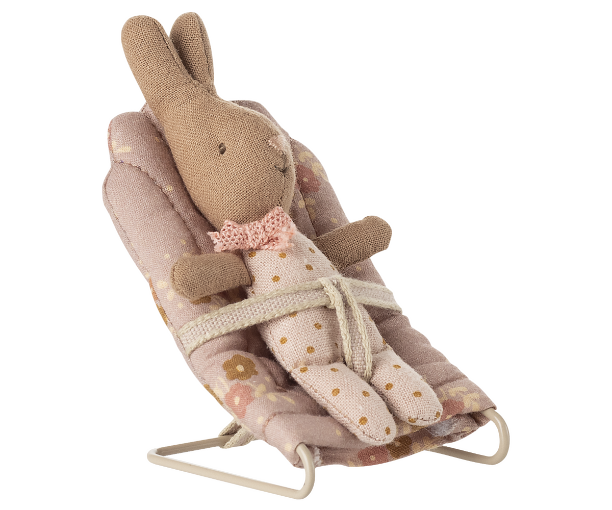 Kleiner Stoffhase im geblümten Anzug sitzt mit dem Band gesichert im rosa Maileg Babysitter My