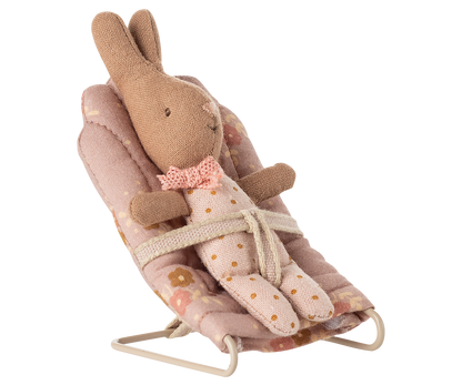 Kleiner Stoffhase im geblümten Anzug sitzt mit dem Band gesichert im rosa Maileg Babysitter My