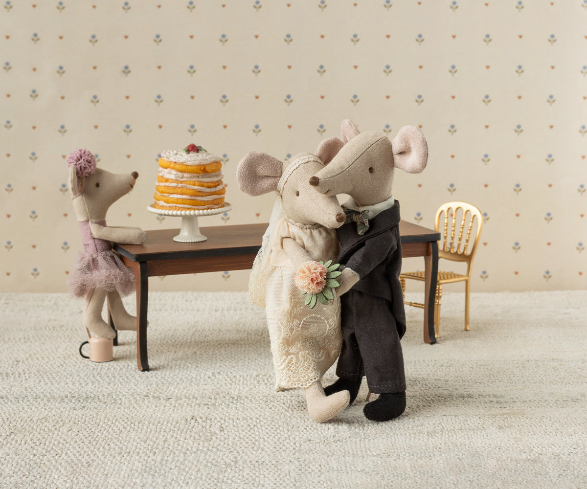 Maileg Hochzeitsmäuse tanzen eng umschlungen vor einem Tisch mit Hochzeitstorte, daneben eine kleine Maus