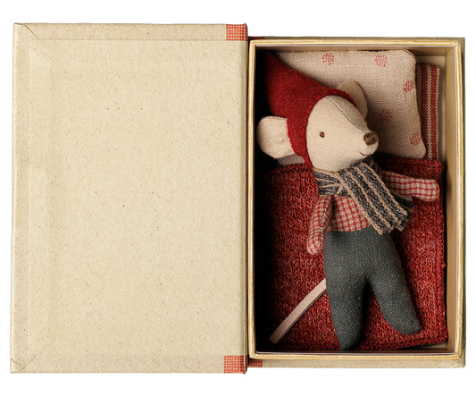 Aufgeklapptes Maileg Buch von oben: die Babymaus mit roter Mütze liegt im Bett unter einer roten Decke