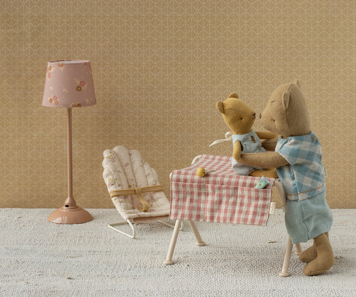 Maileg Babysitter Mikro in Creme steht neben einem Tisch, an dem zwei Teddybären spielen
