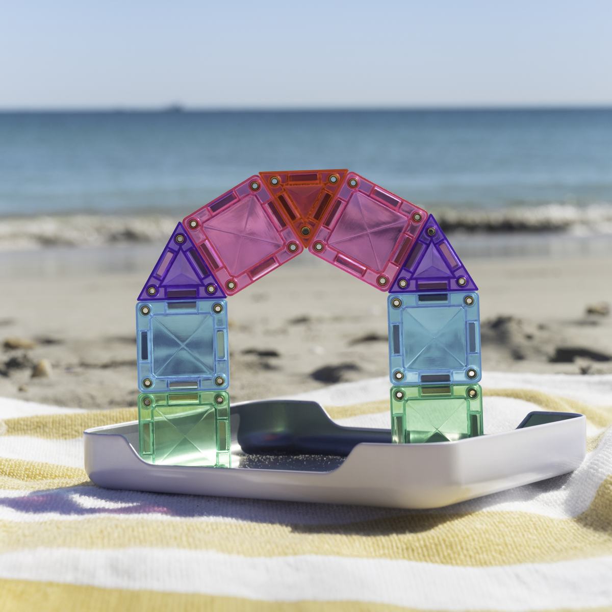 Bogen aus Mini-Magnetbausteinen am Strand auf dem Kofferdeckel