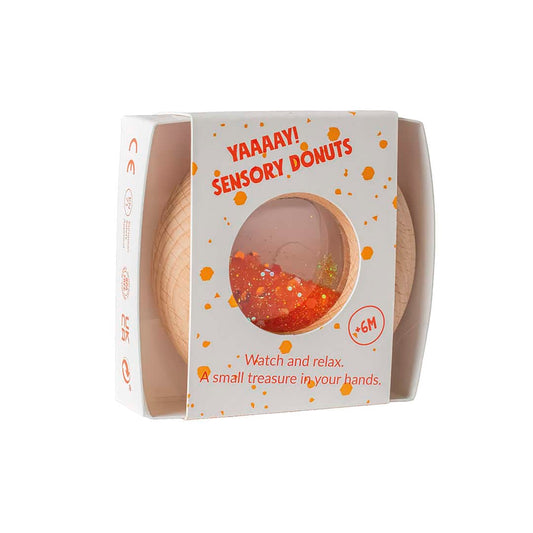 Verpackung des Petit Boum Calm Donut mit orange-weißem Design und Fenster zum Sensorikspielzeug