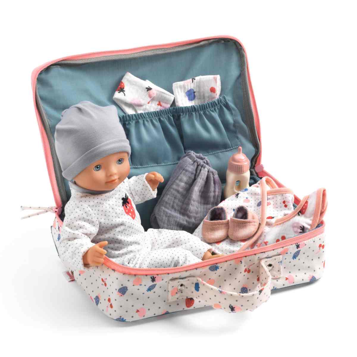 Pomea Puppe Vanille in geöffnetem Koffer mit grauer Mütze, Strampler, Kleidung, rosa Schuhen und Fläschchen