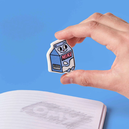 OMY Eraser Buddies Radierer Milchkarton wird von einer Hand vor blauem Hintergrund gehalten