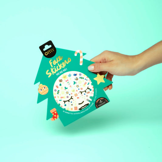 OMY Magic Tree Gesichtssticker, grüne Verpackung mit Smiley-Gesicht und bunten Motiven, Hand greift danach