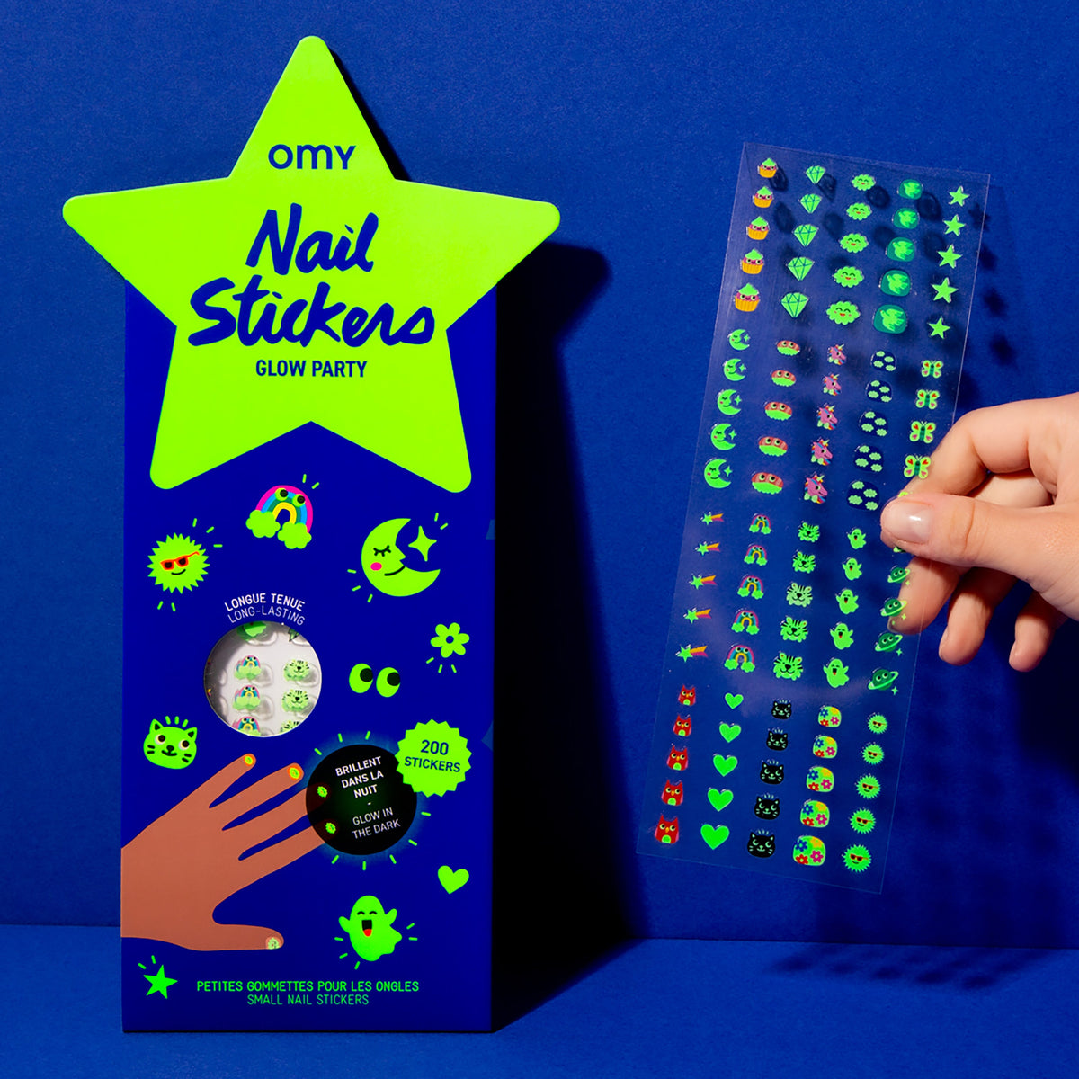 OMY Nagelsticker Glow Party, neonfarbige Sternverpackung und Hand hält Sticker-Bogen mit leuchtenden Motiven