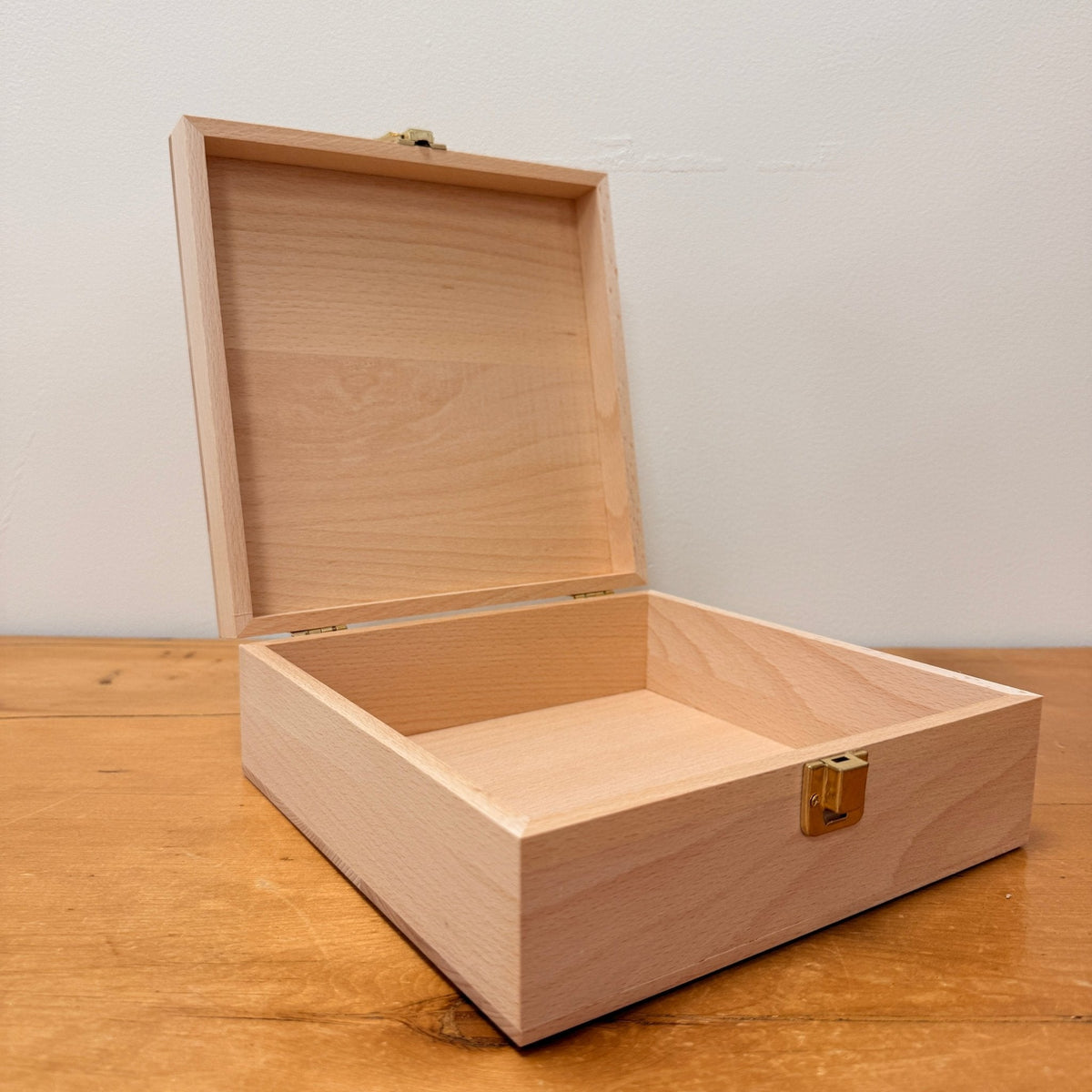 Toverlux Aufbewahrungsbox aus hellem Holz, geöffnet, mit aufgeklapptem Deckel und Metallverschluss