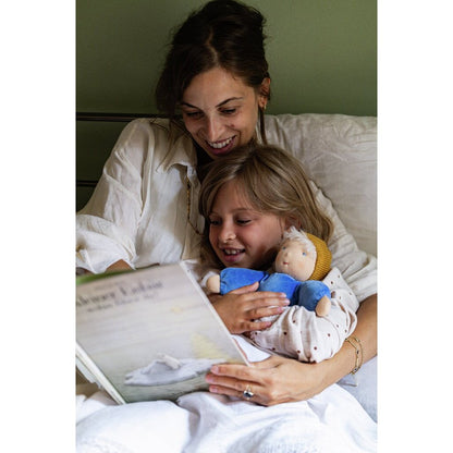 Frau und Kind lesen im Bett ein Buch, das Kind hält die Käthe Kruse Waldorfpuppe NANA wolke im Arm