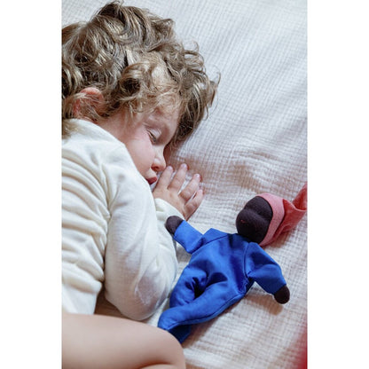 Schlafendes Kleinkind mit Locken liegt neben der Käthe Kruse Waldorfpuppe NINI Sommerwolke im blauen Anzug