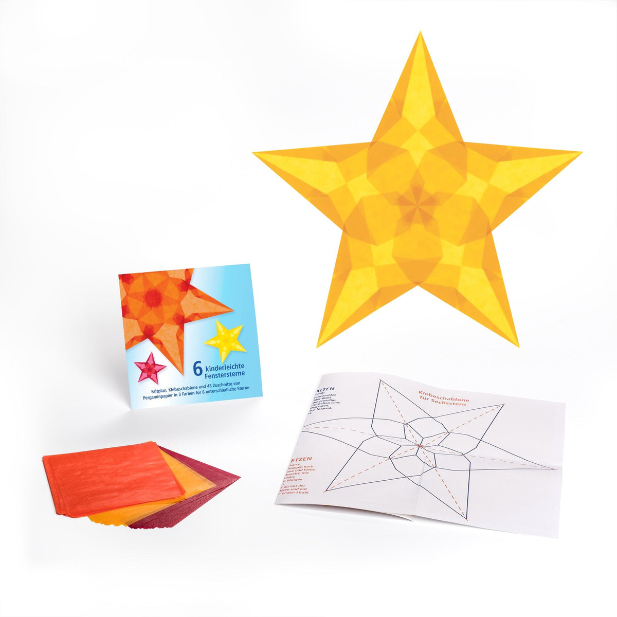 Ausgepacktes Set 6 kinderleichte Fenstersterne: Kartontasche, Pergaminpapier in Rot, Orange und Gelb, Faltplan und ein fertiger goldgelber Stern