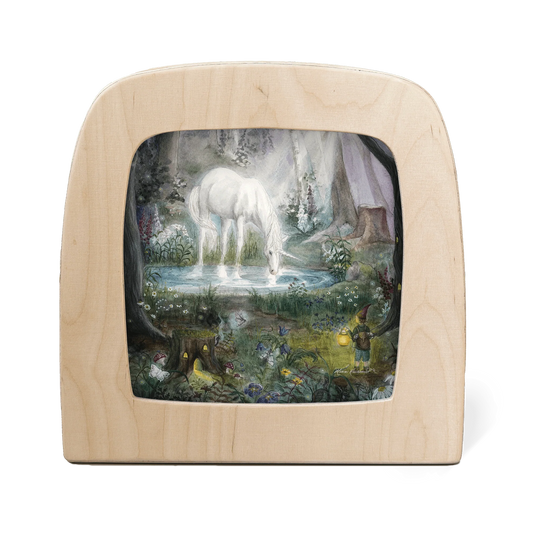 Toverlux Silhouettenlampe mit hellem Holzrahmen, darin Waldszene mit weißem Pferd an Wasserquelle und grünen Felsen