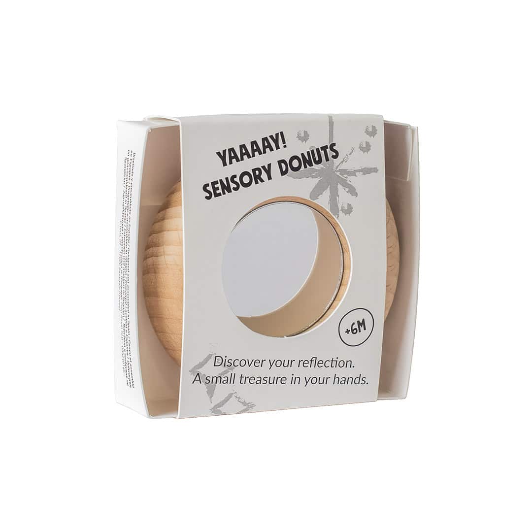 Petit Boum Reflect Donut in Verpackung, beige Holzdonut mit Spiegeleinsatz durch Fenster sichtbar