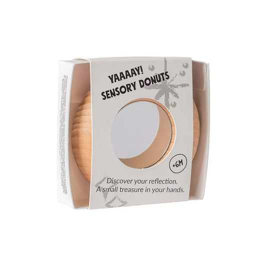 Petit Boum Reflect Donut in Verpackung, beige Holzdonut mit Spiegeleinsatz durch Fenster sichtbar
