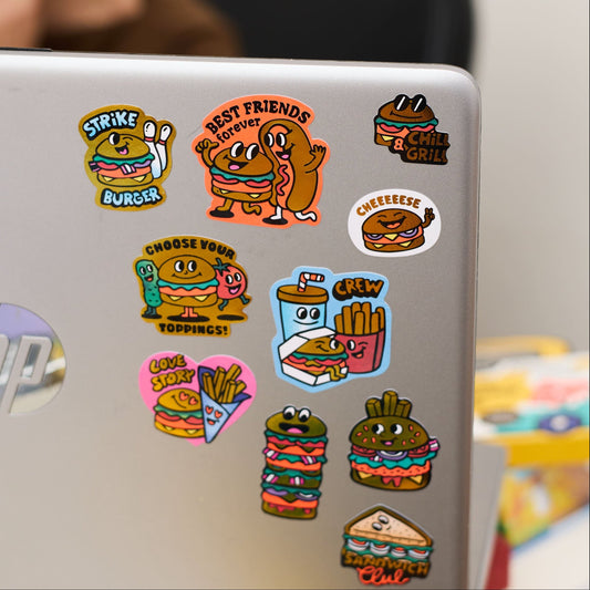OMY Big Burger Sticker, neun bunte Burger- und Fastfood-Motive auf einer silbernen Laptop-Oberfläche