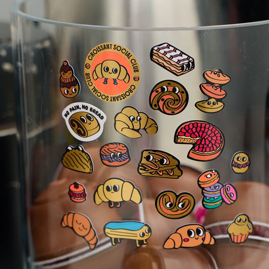 OMY Iconic Croissant Sticker auf transparenter Folie, bunte Aufkleber mit Backwaren-Motiven und lächelnden Charakteren