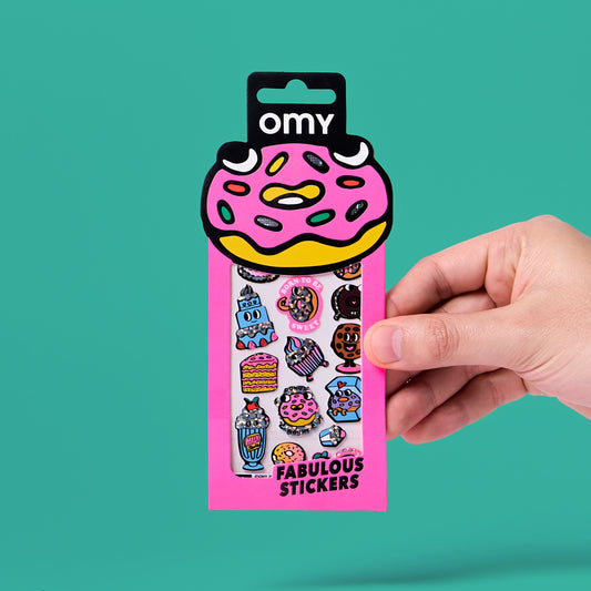 OMY Sticker-Set Iconic Donuts in rosa Verpackung mit bunten Donut- und Süßigkeiten-Motiven, von einer Hand gehalten