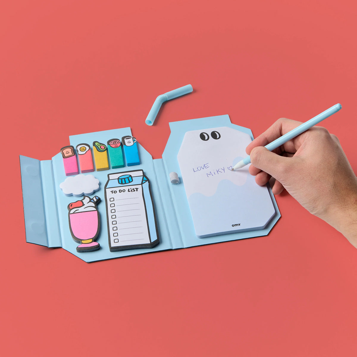OMY Miky Notes Haftnotizen in blauer Milchkarton-Form, offene Vorderseite mit Notizzetteln, Stiften und Zubehör, Hand