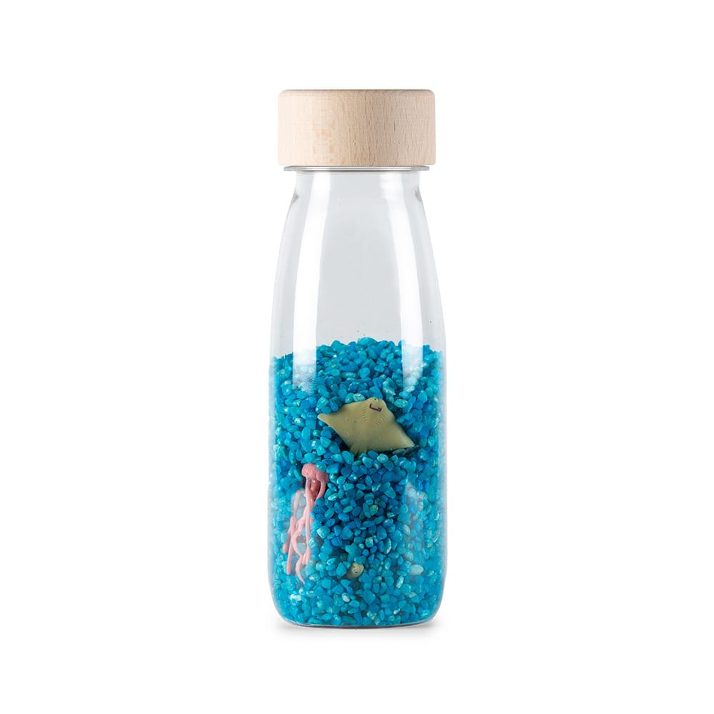 Petit Boum Spy Bottle Sea, Kunststoffflasche mit Holzdeckel, gefüllt mit blauem Granulat, darin Meerestiere wie ein Seepferdchen