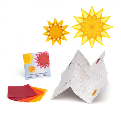 Ausgepacktes Set Wundervolle Fenstersterne: Kartontasche, Pergaminpapier in Rot, Orange und Gelb, aufgestellter Faltplan und zwei fertige Sterne in Gelb und Orange