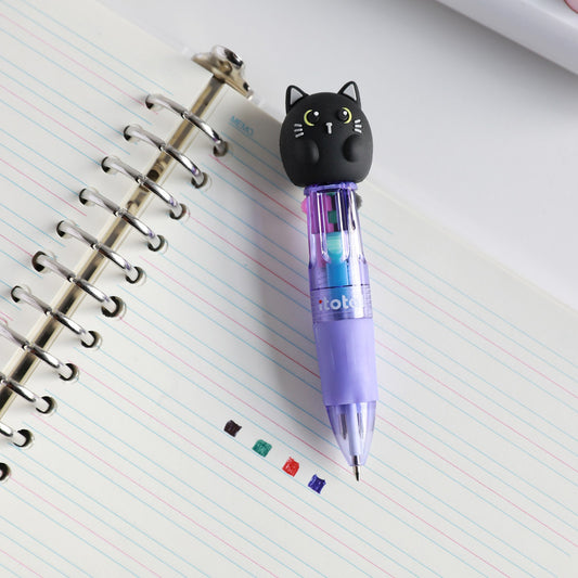 Mini-Stift mit Kopf als schwarze Katze auf einem Spiralblock, daneben Punkte in den vier Tintenfarben